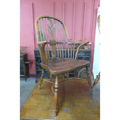 18 - A Gothic style oak x-frame refectory table and a set of six elm and oak Windsor chairs