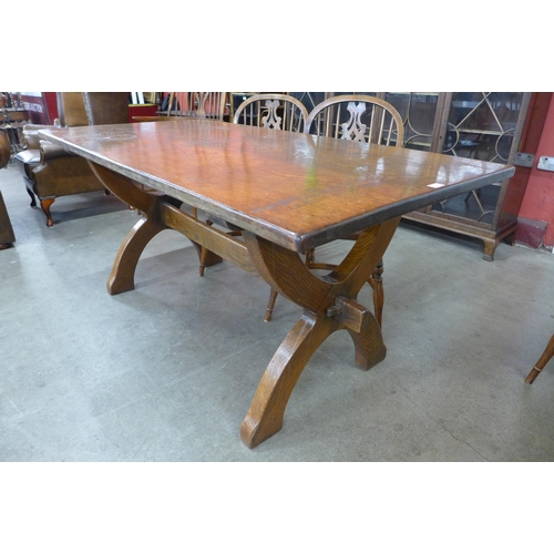 18 - A Gothic style oak x-frame refectory table and a set of six elm and oak Windsor chairs