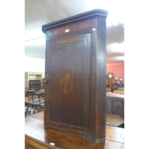 185 - A George III inlaid oak splay front wall hanging corner cupboard