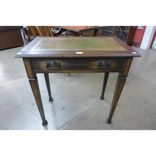 19 - An Arts and Crafts oak and green leather topped single drawer writing table