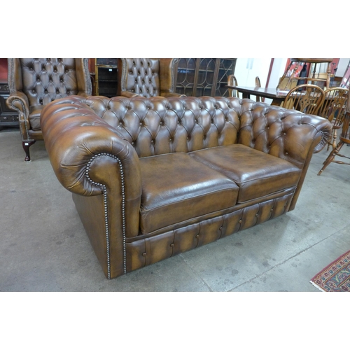 25 - A chestnut brown leather Chesterfield settee