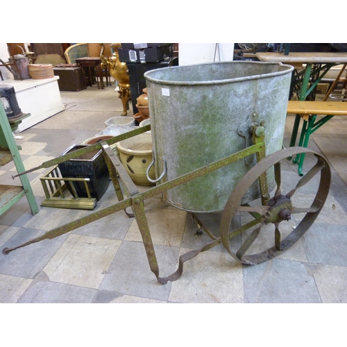 284 - An agricultural galvanised tank on a wrought iron wheel base