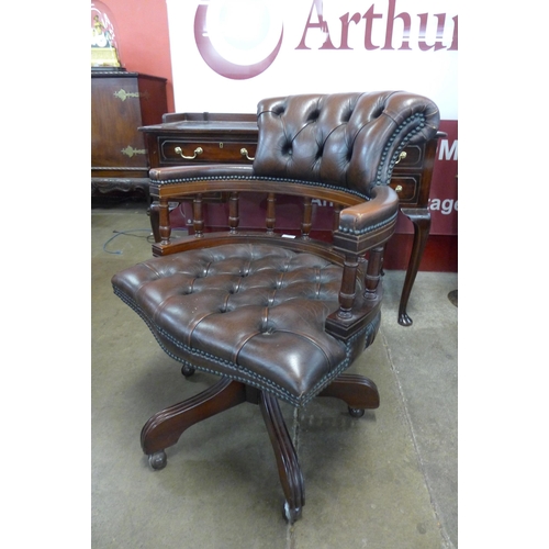 29 - A mahogany and brown leather revolving Captain's desk chair