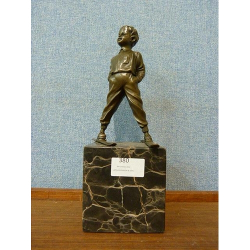 380 - A bronze figure of a young boy skier, on black marble socle, 29cms h