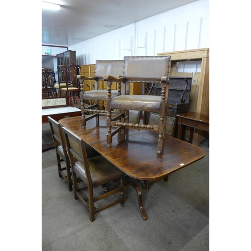 52 - A George III style oak pedestal dining table and a set of six oak and leather upholstered dining cha... 