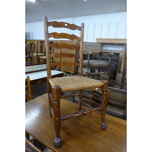 53 - An oak refectory table and a set of four elm rush seated ladderback chairs (one chair a/f)