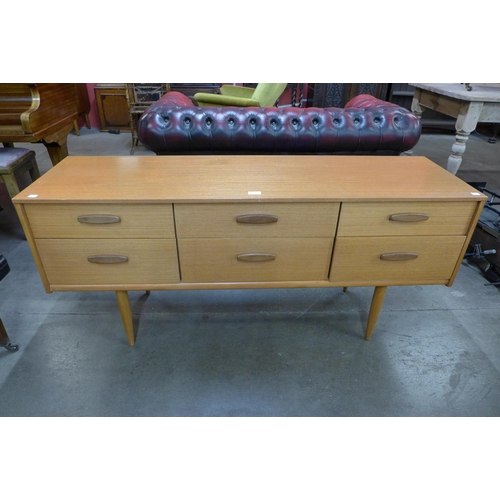 77 - A teak six drawer sideboard