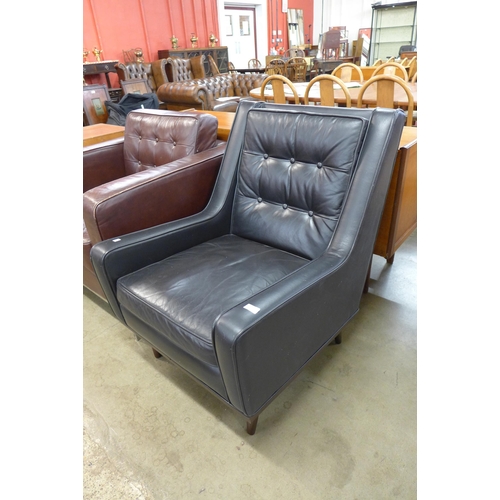 85 - A teak and black vinyl armchair