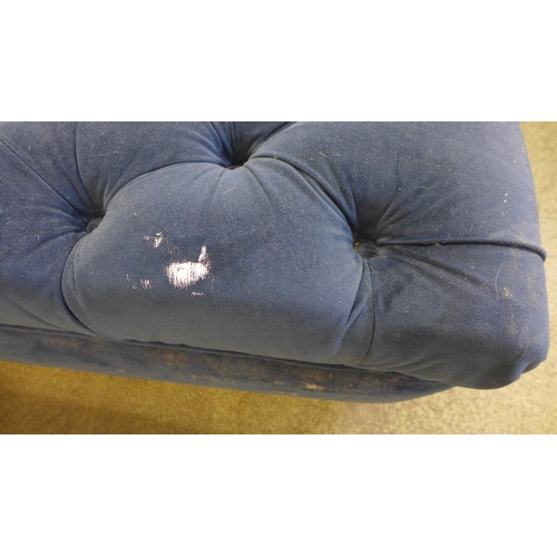 1493 - A blue velvet four seater sofa and footstool