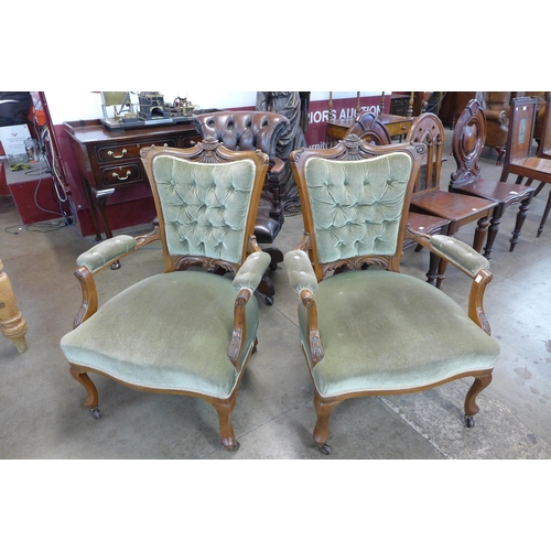 130 - A pair of late Victorian carved walnut and green fabric upholstered open armchairs