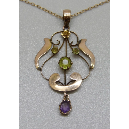 945 - A 9ct gold Art Nouveau, amethyst and peridot pendant on a fine 9ct gold chain, 2.1g