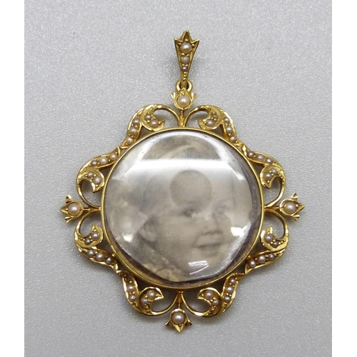 947 - A 15ct gold photograph pendant set with seed pearls, marked 15ct, total weight 7.6g, 36mm