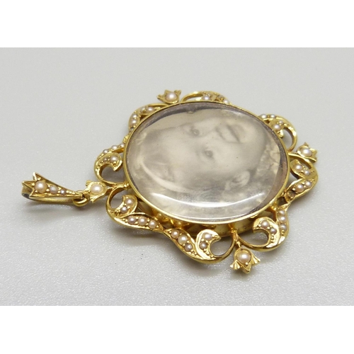 947 - A 15ct gold photograph pendant set with seed pearls, marked 15ct, total weight 7.6g, 36mm