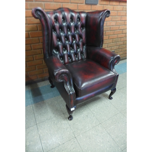 1 - An oxblood red leather wingback armchair