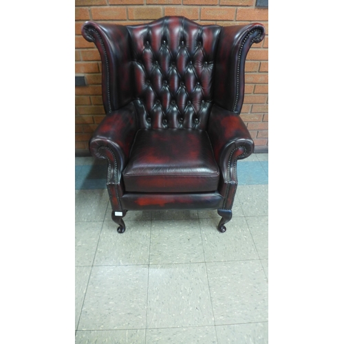 1 - An oxblood red leather wingback armchair