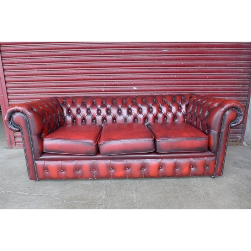 105b - A red leather Chesterfield three seater sofa