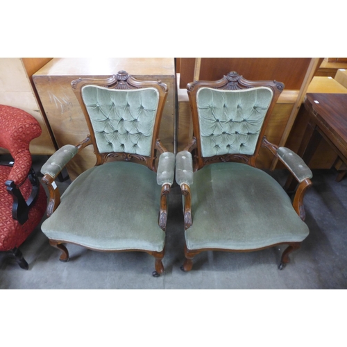 130 - A pair of late Victorian carved walnut and green fabric upholstered open armchairs