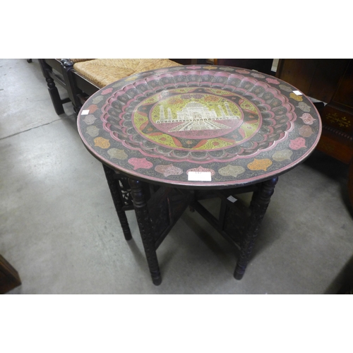 147 - An Indian carved wood and painted brass topped occasional table