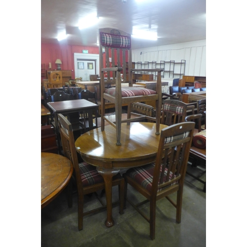 196 - An oval oak dining table and four Arts and Crafts oak chairs