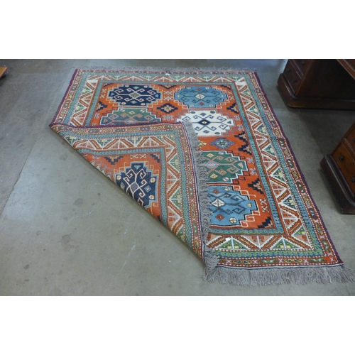 98 - An eastern terracotta ground rug, 206 x 195cms