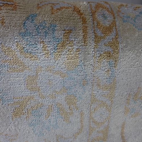 1524 - A champagne and blue patterned rug