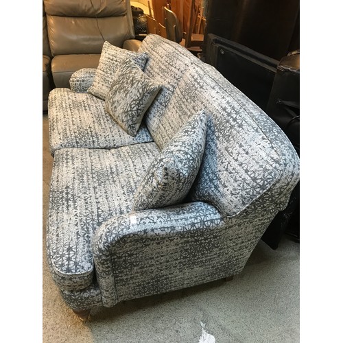 1499 - A patterned upholstered two seater sofa on casters