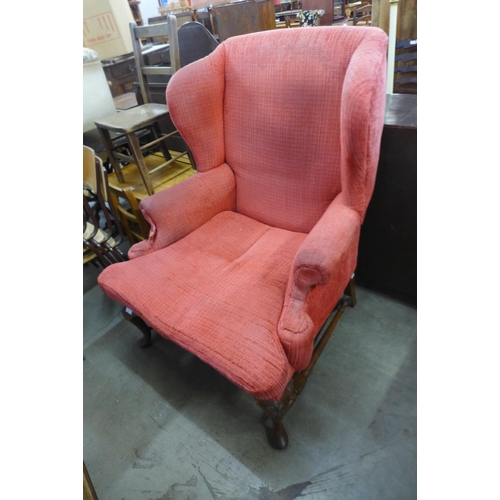 185 - An early 20th Century Queen Anne style walnut and fabric upholstered wingback armchair