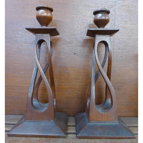 608 - A pair of Arts and Crafts carved oak candlesticks, 26cm