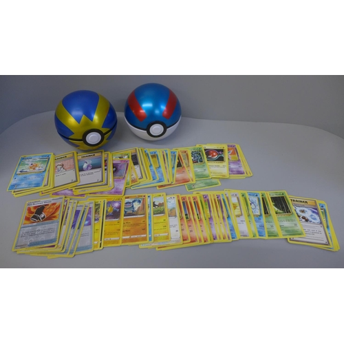655 - 100 Pokemon cards, including holographic and two Pokeball tins