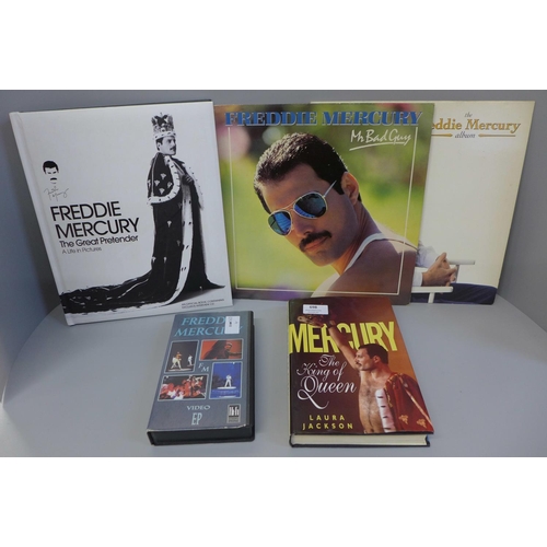 677 - Two Freddie Mercury LP records, two books including Freddie Mercury The Great Pretender and a VHS vi... 