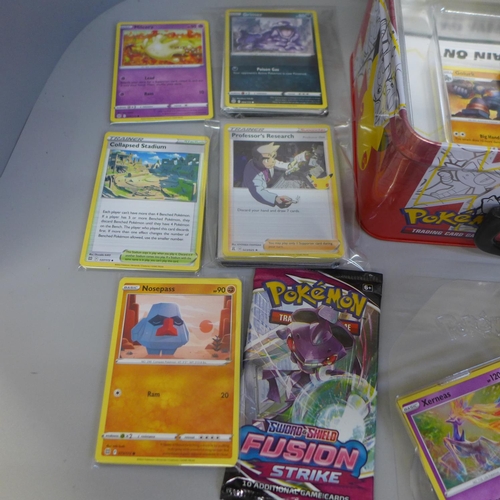 709 - A collection of various Pokemon cards and coins, folders, keyrings, a poster, etc.