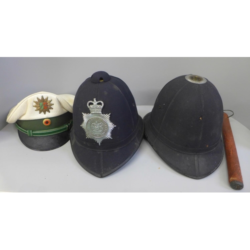 758 - A German police cap, a Nottinghamshire Constabulary helmet, one other police helmet and a truncheon