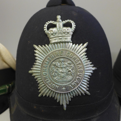 758 - A German police cap, a Nottinghamshire Constabulary helmet, one other police helmet and a truncheon