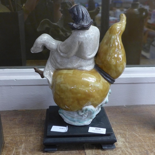 804 - A ceramic figure on a wooden base