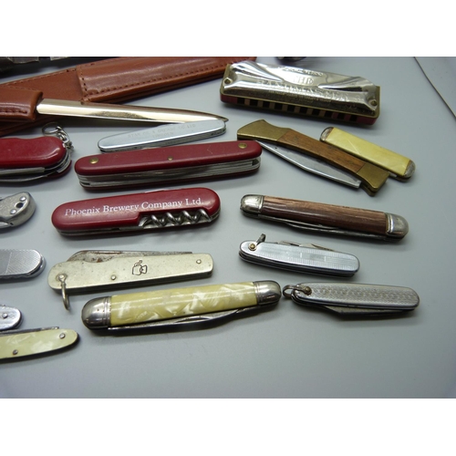 829 - A collection of penknives, a letter opener, a harmonica, etc.