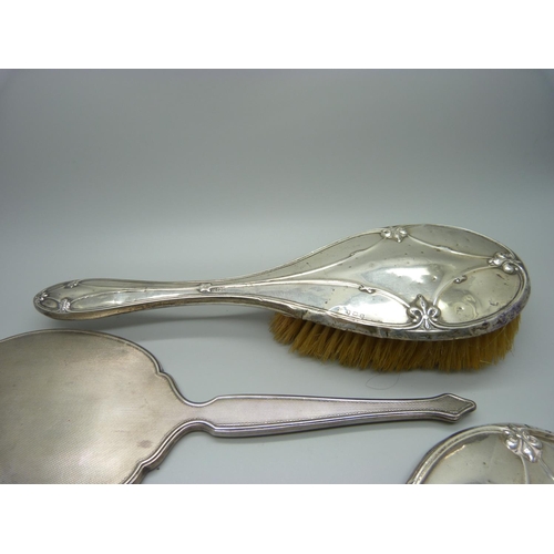 853 - A silver backed mirror, two silver backed brushes, a/f, and a silver mirror back for scrap