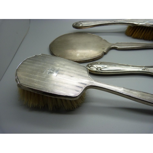 853 - A silver backed mirror, two silver backed brushes, a/f, and a silver mirror back for scrap