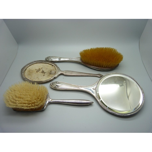 853 - A silver backed mirror, two silver backed brushes, a/f, and a silver mirror back for scrap