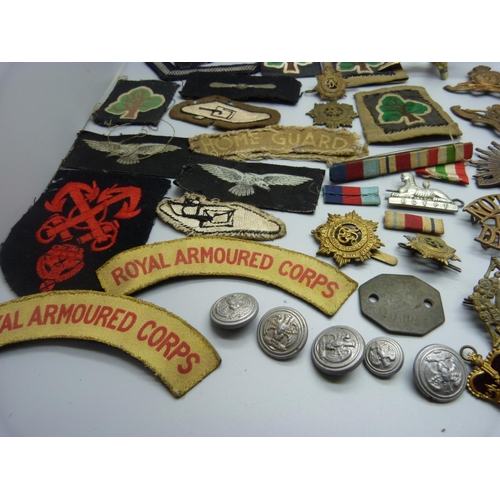 879 - A collection of military cap badges, patches, buttons and a silver ARP badge