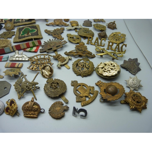 879 - A collection of military cap badges, patches, buttons and a silver ARP badge