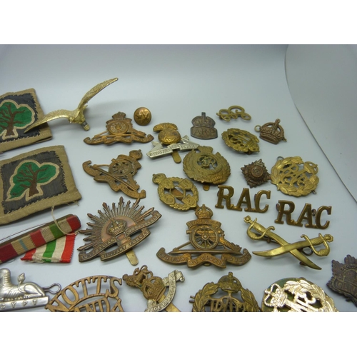 879 - A collection of military cap badges, patches, buttons and a silver ARP badge