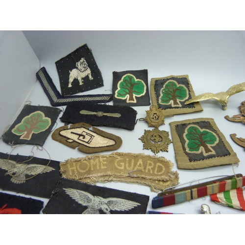 879 - A collection of military cap badges, patches, buttons and a silver ARP badge