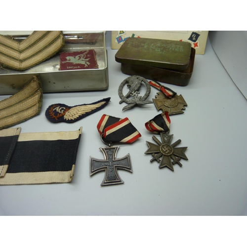 883 - A collection of WWII period military items, including three German cross medals, a German anti-aircr... 