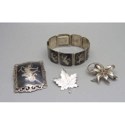 944 - A Thai silver bracelet and brooch and two other silver brooches