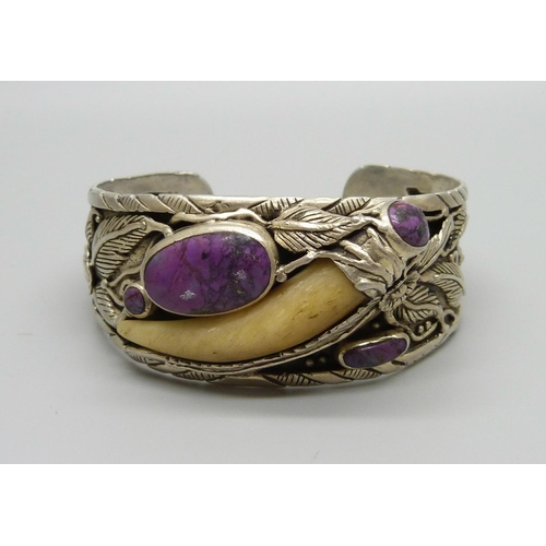 977 - An Arts and Crafts style silver bangle set with a tooth and purple stones, marked 925