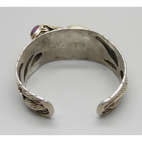 977 - An Arts and Crafts style silver bangle set with a tooth and purple stones, marked 925