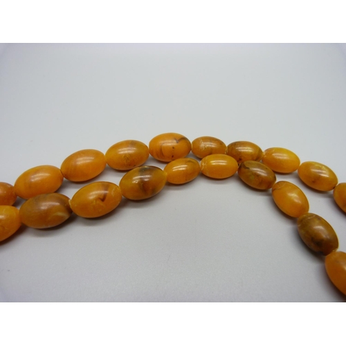 990 - An amber coloured bead necklace, 37.8g