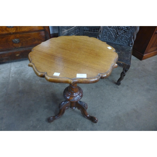 106 - A Chippendale style carved mahogany and walnut tripod wine table