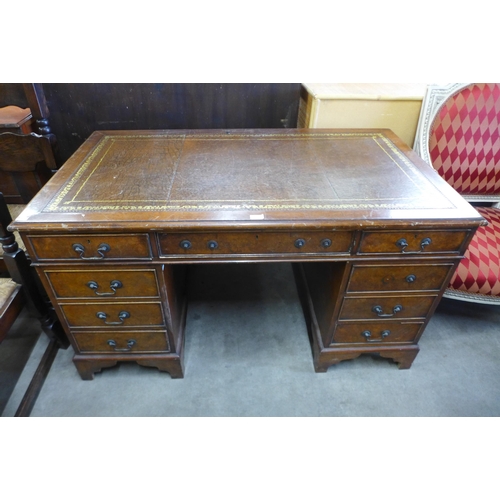 144 - A walnut and brown leather topped pedestal desk