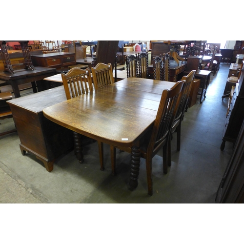 176 - An early 20th century oak extending dining table and four chairs.